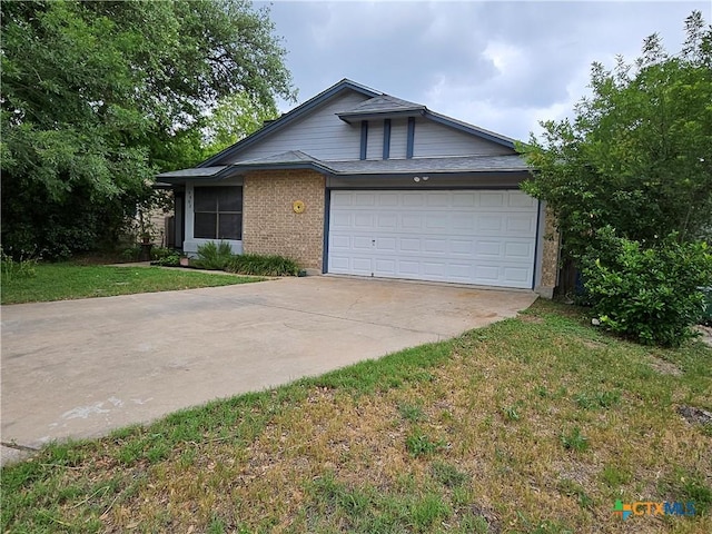 view of front of house featuring a garage, driveway, a front lawn, and brick siding