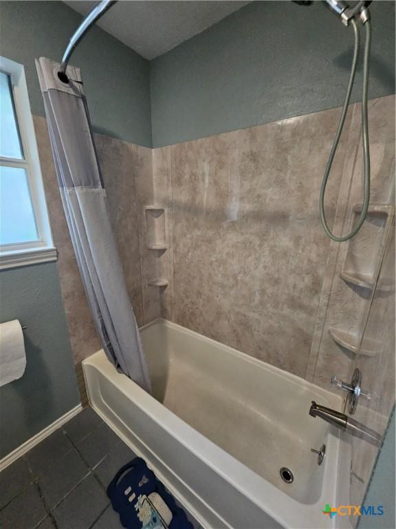 bathroom featuring shower / bathtub combination with curtain and tile patterned flooring