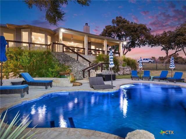 pool at dusk featuring a patio area