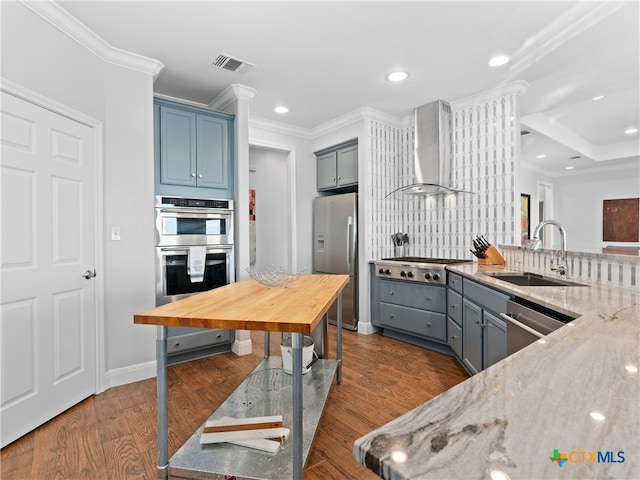 kitchen with light stone countertops, sink, wall chimney exhaust hood, stainless steel appliances, and tasteful backsplash