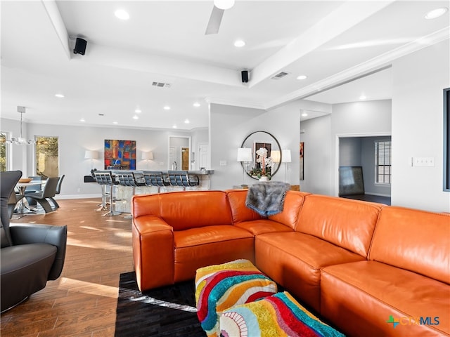 living room with ceiling fan with notable chandelier, wood-type flooring, and ornamental molding