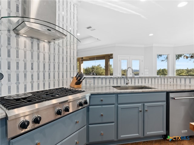 kitchen featuring stainless steel gas stovetop, sink, decorative backsplash, light stone counters, and island exhaust hood