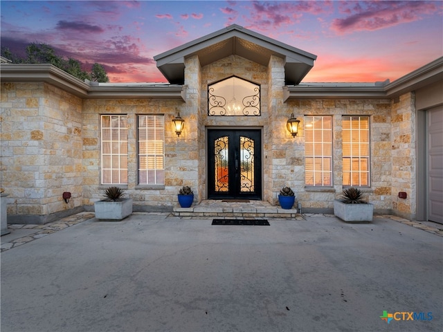 exterior entry at dusk featuring french doors