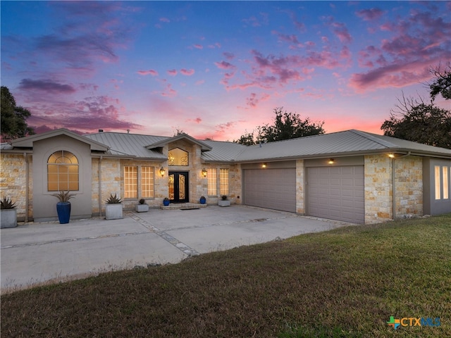 view of front facade with a yard and a garage