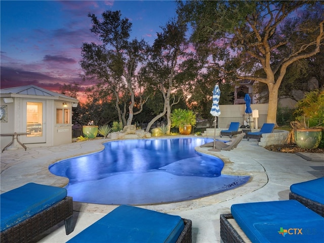 pool at dusk with a patio