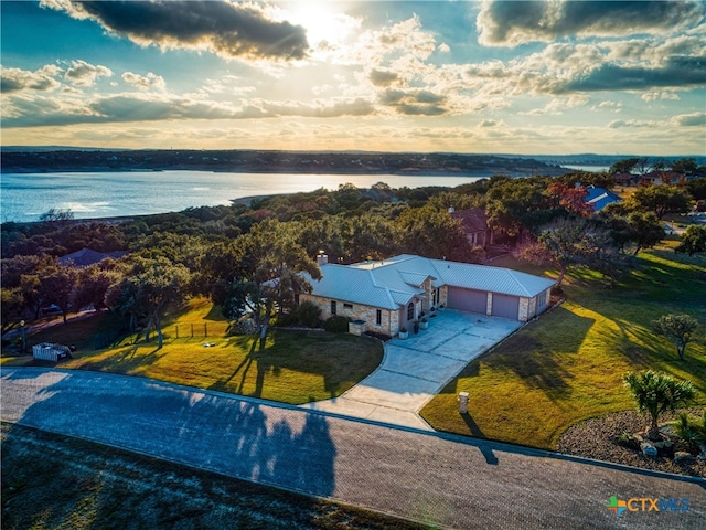 aerial view at dusk featuring a water view