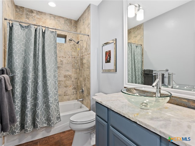 full bathroom featuring shower / tub combo, vanity, hardwood / wood-style flooring, and toilet