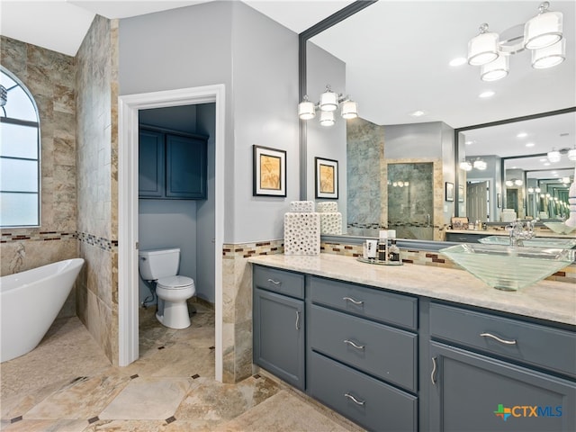 bathroom featuring a washtub, toilet, tile walls, and vanity