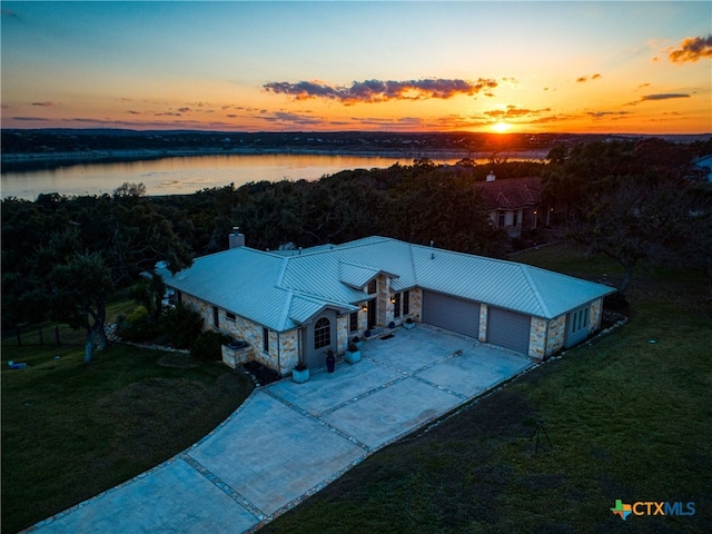 aerial view at dusk featuring a water view