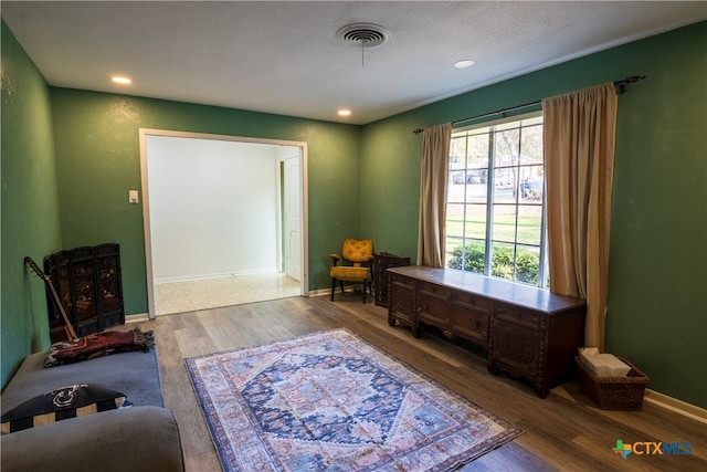 living area with hardwood / wood-style floors and a textured ceiling