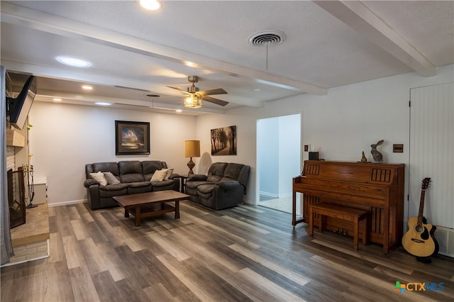 living room featuring a textured ceiling, dark hardwood / wood-style flooring, ceiling fan, and beam ceiling