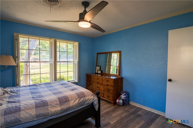 bedroom featuring ornamental molding, dark hardwood / wood-style flooring, a textured ceiling, and ceiling fan