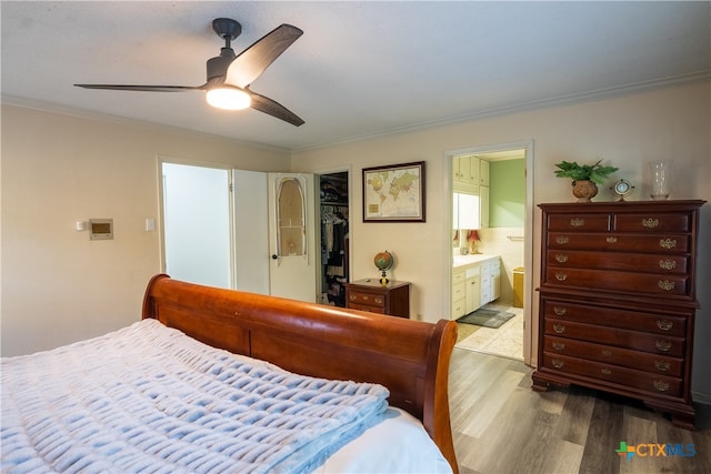 bedroom featuring ensuite bath, ornamental molding, ceiling fan, a closet, and light wood-type flooring