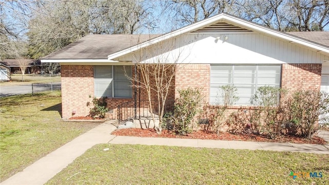 view of property exterior with brick siding and a lawn