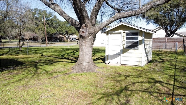 view of yard featuring a storage shed, fence, and an outdoor structure