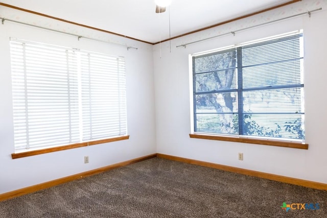 empty room featuring ceiling fan, baseboards, and dark carpet