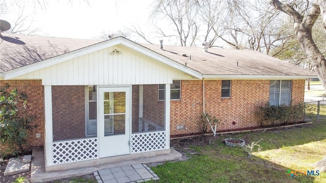 back of property with a sunroom, crawl space, brick siding, and roof with shingles