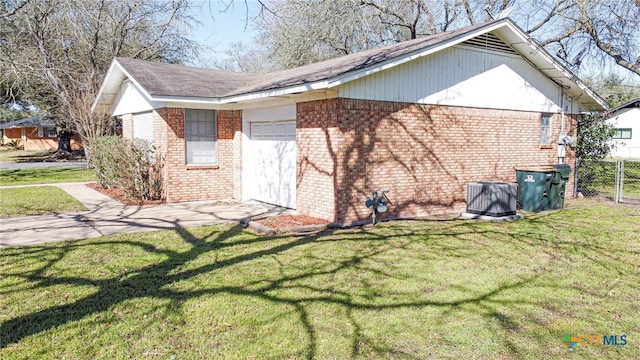 view of side of property featuring brick siding, a lawn, an attached garage, and fence