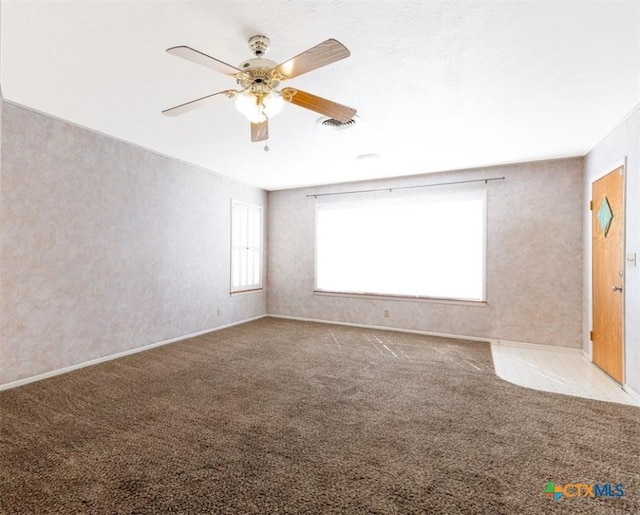 spare room featuring ceiling fan, carpet, and visible vents