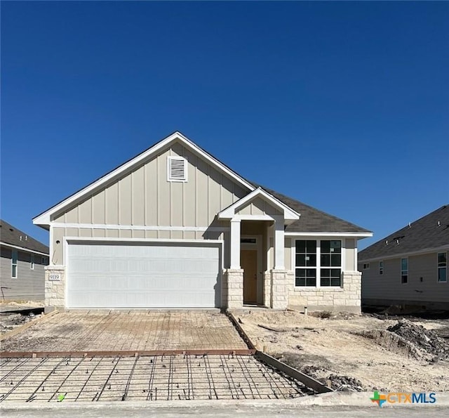 craftsman house featuring a garage and a front lawn