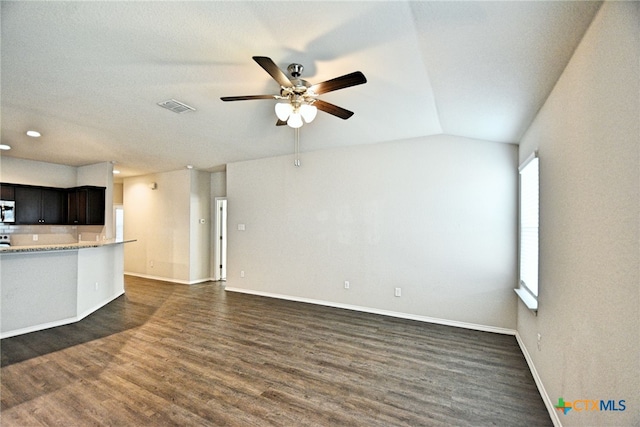 475 Autumn Leaf Dr, New Braunfels, TX 78130 - kitchen with dark wood-type flooring, a ceiling fan, stainless steel microwave, open floor plan, and light stone countertops