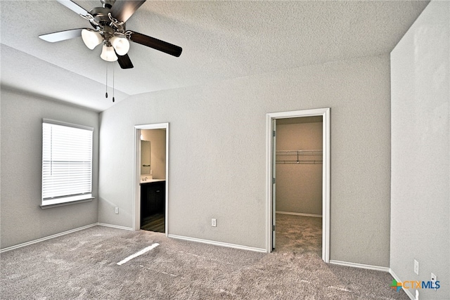 475 Autumn Leaf Dr, New Braunfels, TX 78130 - unfurnished bedroom with a spacious closet, lofted ceiling, carpet floors, ensuite bath, and a closet