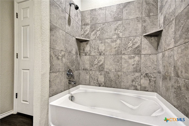 475 Autumn Leaf Dr, New Braunfels, TX 78130 - bathroom with washtub / shower combination, a textured wall, and wood finished floors