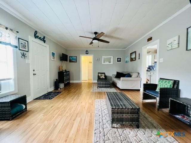 living room with ornamental molding, hardwood / wood-style floors, and ceiling fan