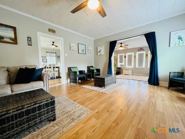 living room with ornamental molding, hardwood / wood-style floors, and ceiling fan