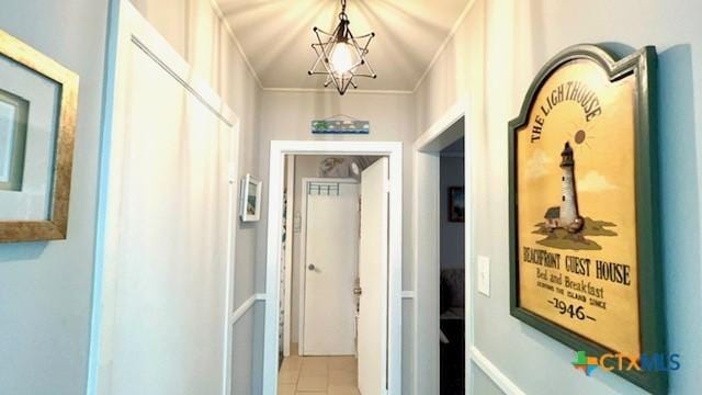 hallway with an inviting chandelier and crown molding