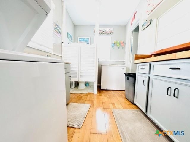 bathroom featuring washer / dryer and hardwood / wood-style floors