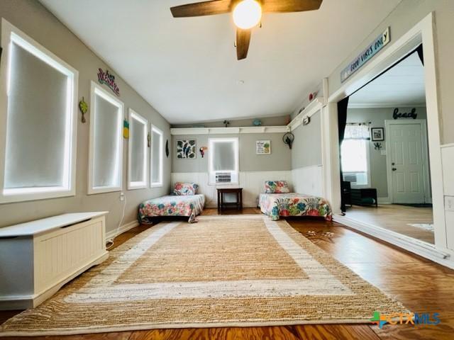 unfurnished bedroom with hardwood / wood-style flooring, radiator heating unit, ceiling fan, and vaulted ceiling