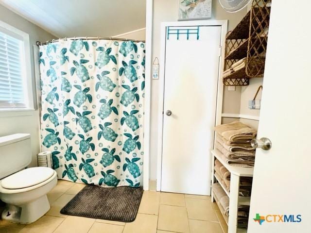 bathroom featuring walk in shower, tile patterned floors, and toilet