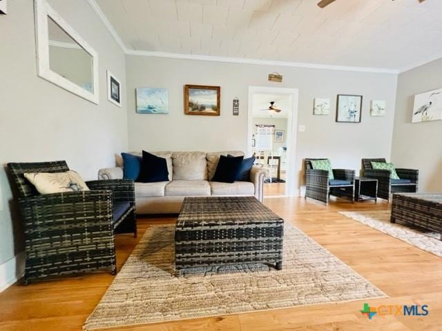 living room with hardwood / wood-style flooring, ceiling fan, and crown molding