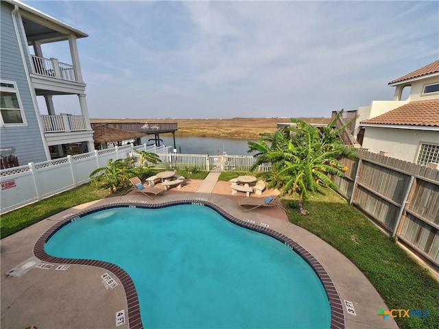 view of pool with a patio and a water view