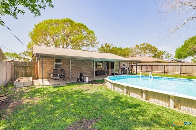 118 Byron Ln, Victoria, TX 77901 - rear view of property with a fenced backyard, a patio, brick siding, and a garden
