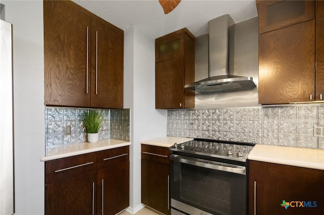 118 Byron Ln, Victoria, TX 77901 - kitchen with stainless steel range with electric stovetop, wall chimney exhaust hood, tasteful backsplash, and light countertops