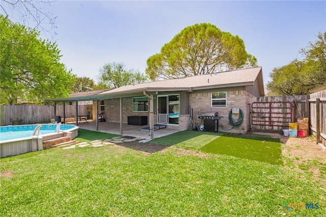 118 Byron Ln, Victoria, TX 77901 - back of property with a fenced backyard, brick siding, and a patio area