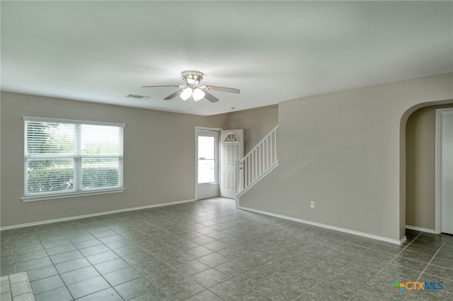 1335 Lakeside Loop, Round Rock, TX 78665 - spare room with arched walkways, ceiling fan, and dark tile patterned flooring
