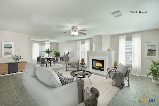 1335 Lakeside Loop, Round Rock, TX 78665 - tiled living area featuring healthy amount of natural light, a tile fireplace, and a ceiling fan