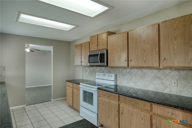 1335 Lakeside Loop, Round Rock, TX 78665 - kitchen with stainless steel microwave, white electric stove, backsplash, a ceiling fan, and dark stone counters