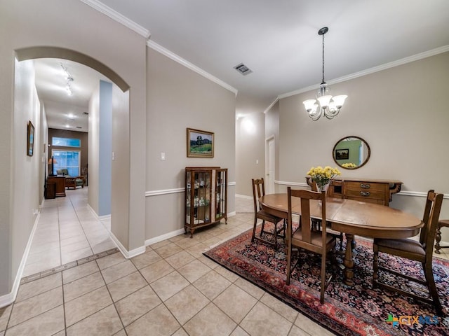 2615 Foresthaven Dr, New Braunfels, TX 78132 - dining space featuring light tile patterned floors, arched walkways, crown molding, a chandelier, and baseboards