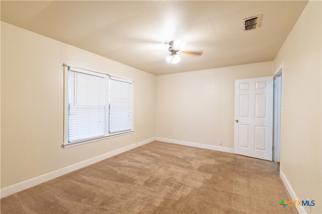 spare room with light colored carpet and ceiling fan