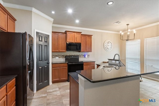 kitchen featuring pendant lighting, an island with sink, sink, ornamental molding, and black appliances