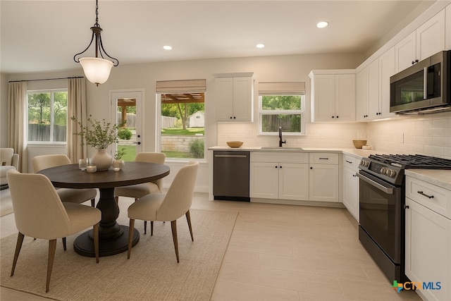 1123 Sundrop Pl, Round Rock, TX 78665 - kitchen with appliances with stainless steel finishes, a sink, decorative backsplash, plenty of natural light, and recessed lighting