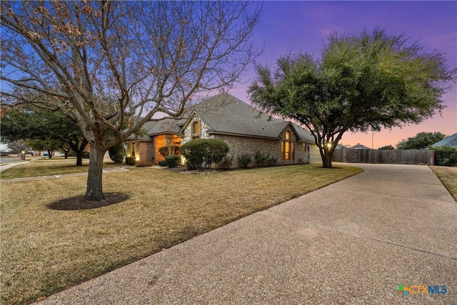 view of front of home with a front lawn, fence, and driveway