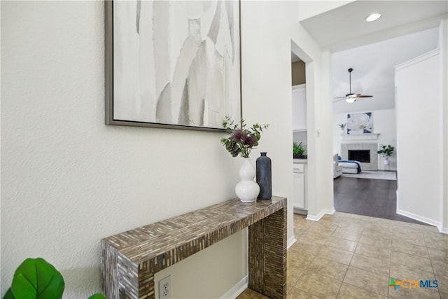 corridor with light tile patterned flooring and baseboards