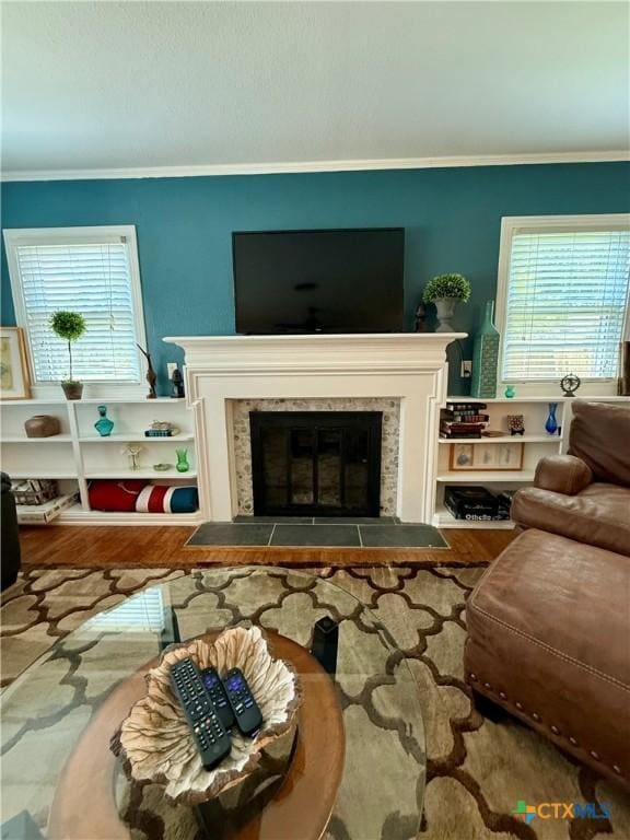 416 W Thompson Ave, Temple, TX 76501 - living area featuring crown molding, a glass covered fireplace, wood finished floors, and healthy amount of natural light