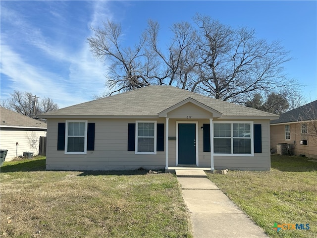 view of front of property with a front lawn and central air condition unit