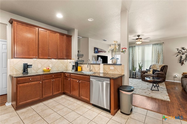 12530 Crockett Way, San Antonio, TX 78253 - kitchen with dishwasher, open floor plan, decorative backsplash, brown cabinets, and dark stone counters